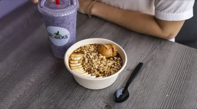 Robeks smoothie and granola-topped bowl with banana slices and peanut butter on a table