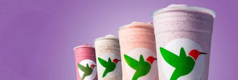 Four colorful Robeks smoothies lined up against a purple background